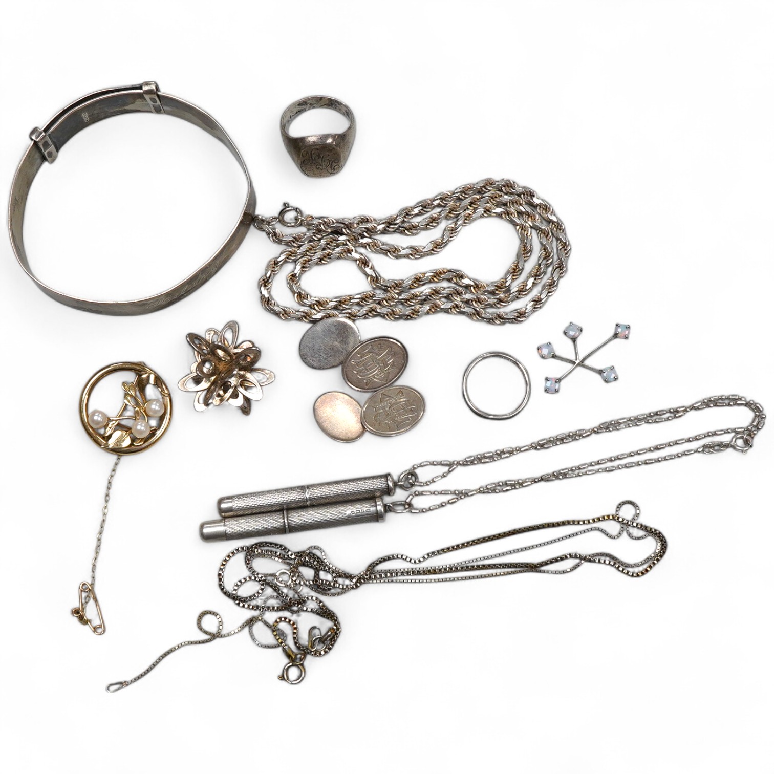 A collection of silver jewels, comprising: a bangle; a chain necklace suspending two winding toothpicks, one with toothpick deficient; a rope twist chain; a pair of cufflinks with the initials DBH; a pendant of abstract
